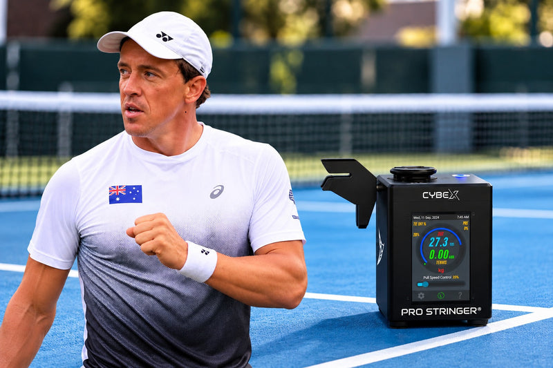 Professional tennis player Rubin Statham with a Pro Stringer electronic machine on a tennis court.