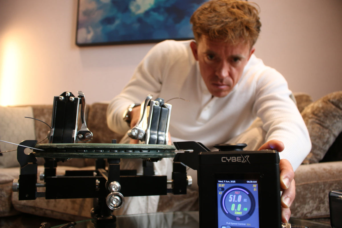 Rubin Statham demonstrating the Pro Stringer CybeX digital tennis stringing machine during a podcast interview.