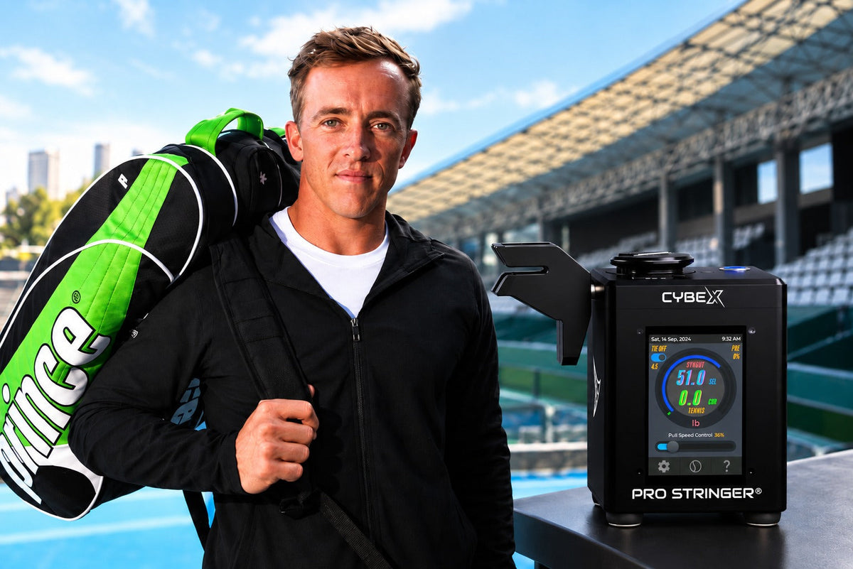 Rubin Statham with a tennis bag standing next to a Pro Stringer CybeX digital tennis stringing machine.