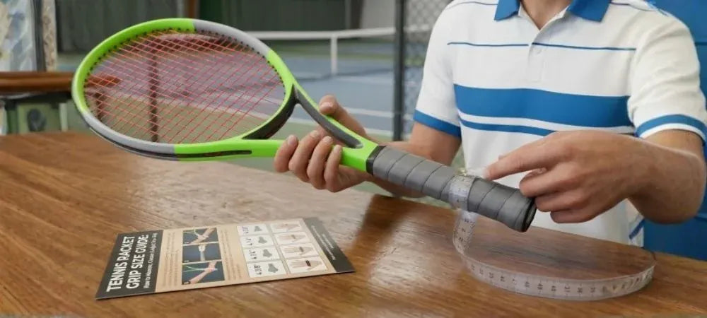 A player wraps a measuring tape around the handle of a tennis racquet, with a grip size guide card on the table