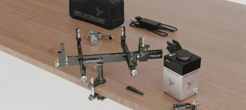 Une machine à corder portable, un système de montage, des pinces et des accessoires disposés sur une table en bois