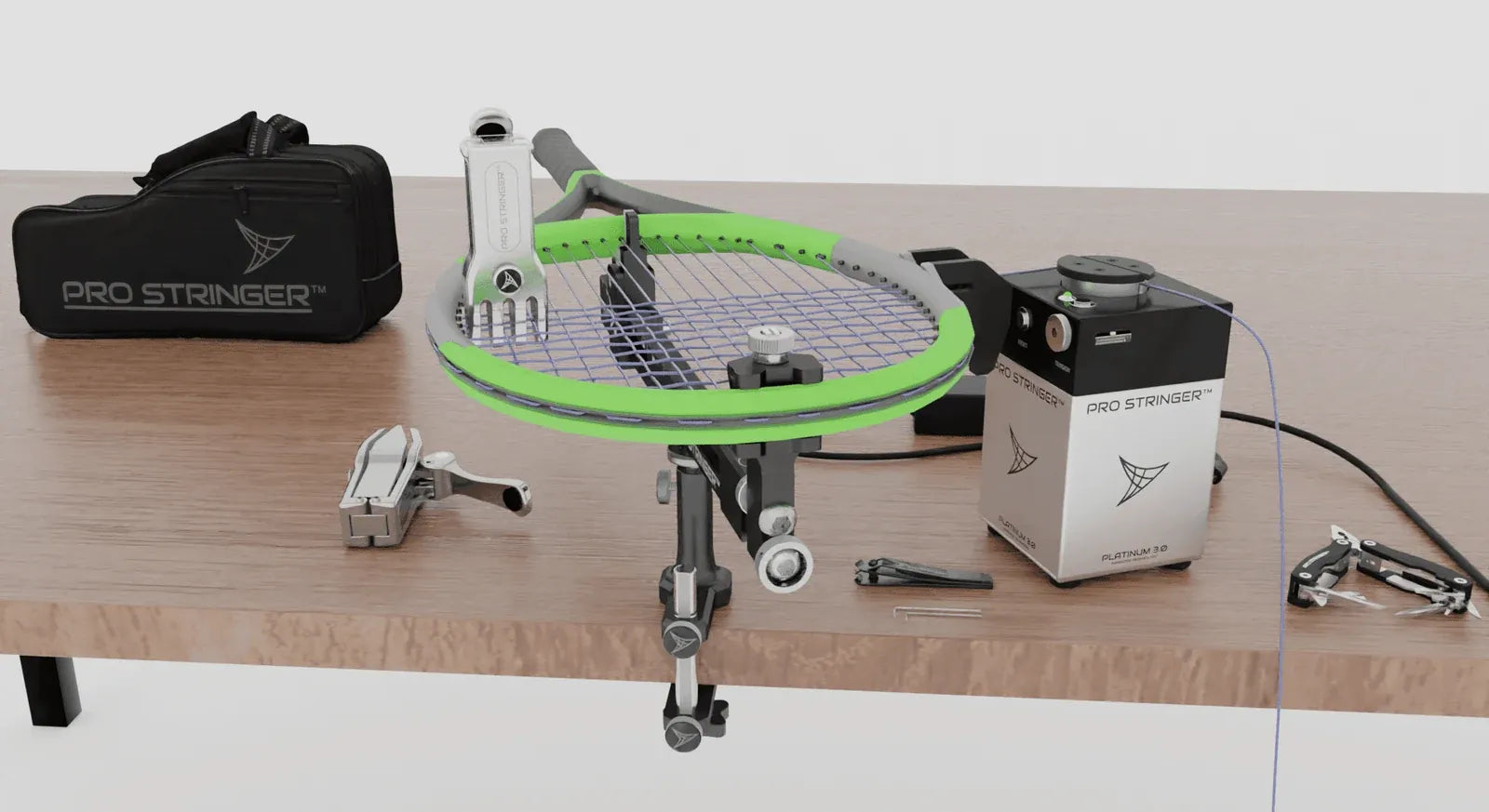 Portable Pro Stringer setup on a table with a racquet mounted and travel bag behind